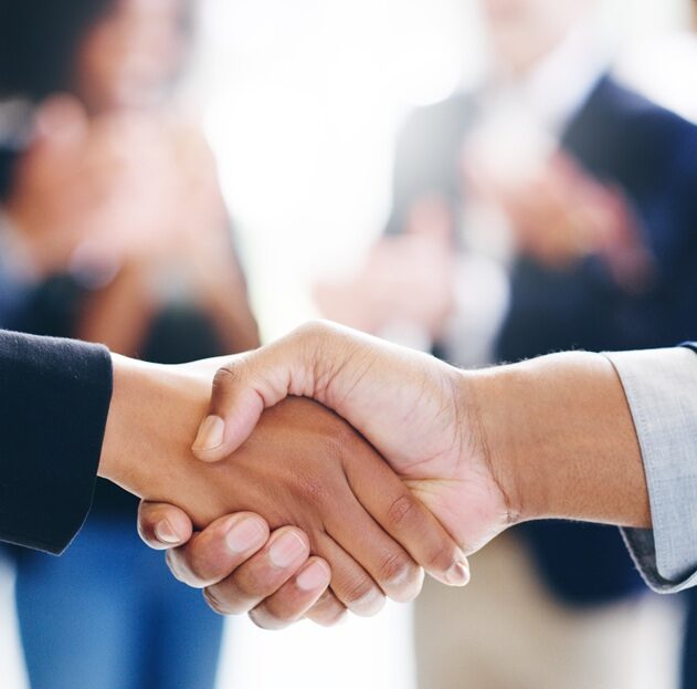 A002_C088_12126X Cropped shot of a businessman and businesswoman shaking hands in a modern office.